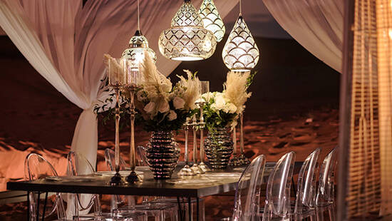 a fancy dinner table set up in the desert at night