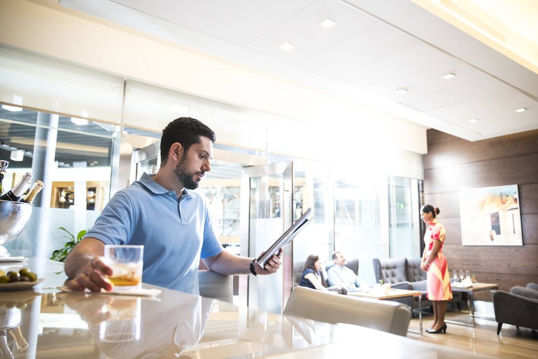 A man having a drink at the bar in a marhaba lounge