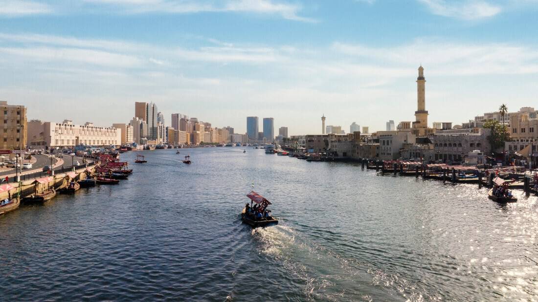 An abra boat on Dubai Creek, backdropped by the city skyline