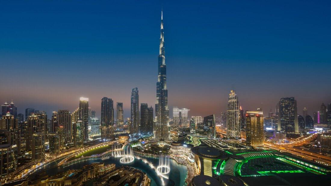 The Burj Khalifa, surrounding skyscrapers and the Dubai Fountain at night 