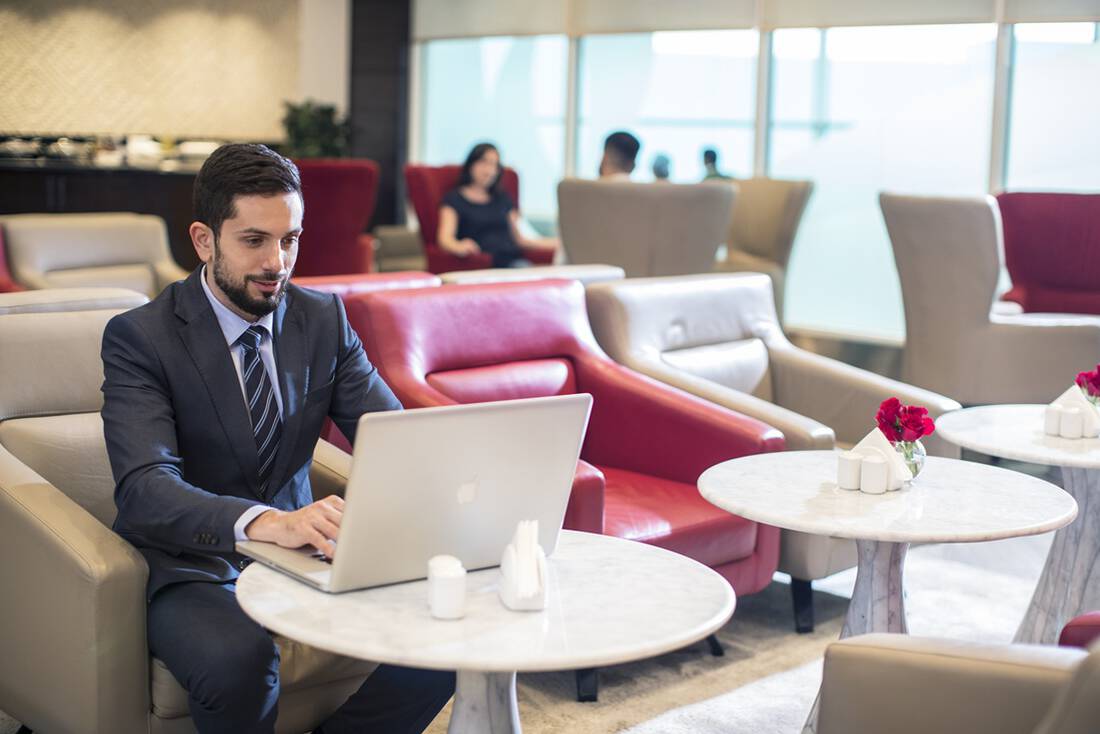 A businessman working on a laptop in a marhaba airport lounge
