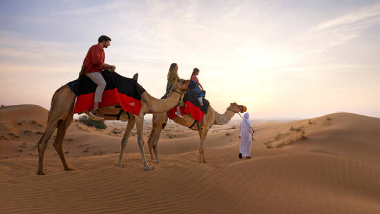 a family on a camel ride in the desert