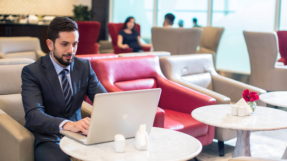 A businessman using a laptop in a marhaba lounge