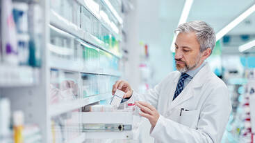 A pharmacist organizing a medicine drawer in a pharmacy