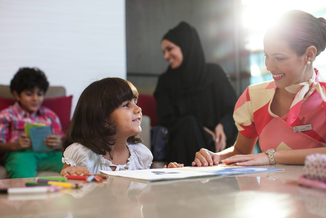 A child with a marhaba representative in an airport lounge family room