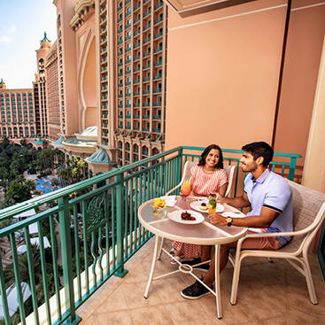 couple hanging out in the balcony of their Atlantis the Palm room