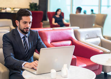 A businessman working on his laptop at a marhaba lounge