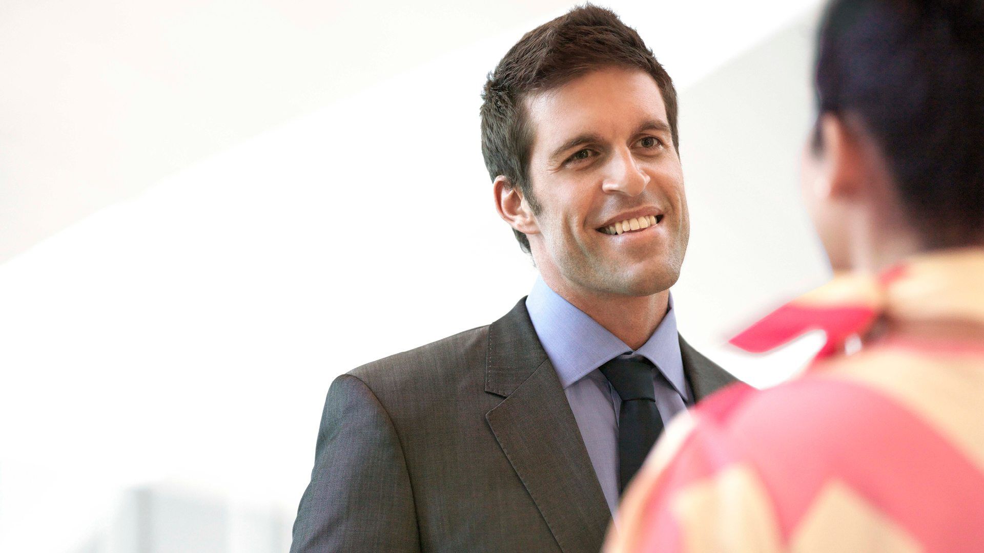 male client in a suit smiling at a female marhaba representative