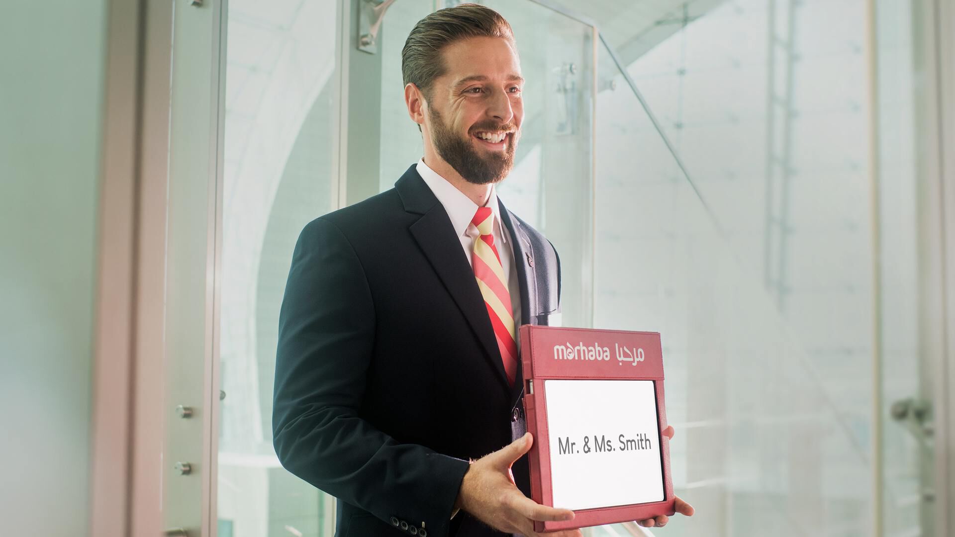 male marhaba representative holding a name sign with Mr. & Ms. Smith written on it