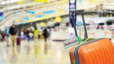 Orange luggage with a Melbourne luggage tag on it