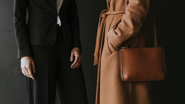 image of a couple of models wearing a brown coat with a brown handbag and a black suit