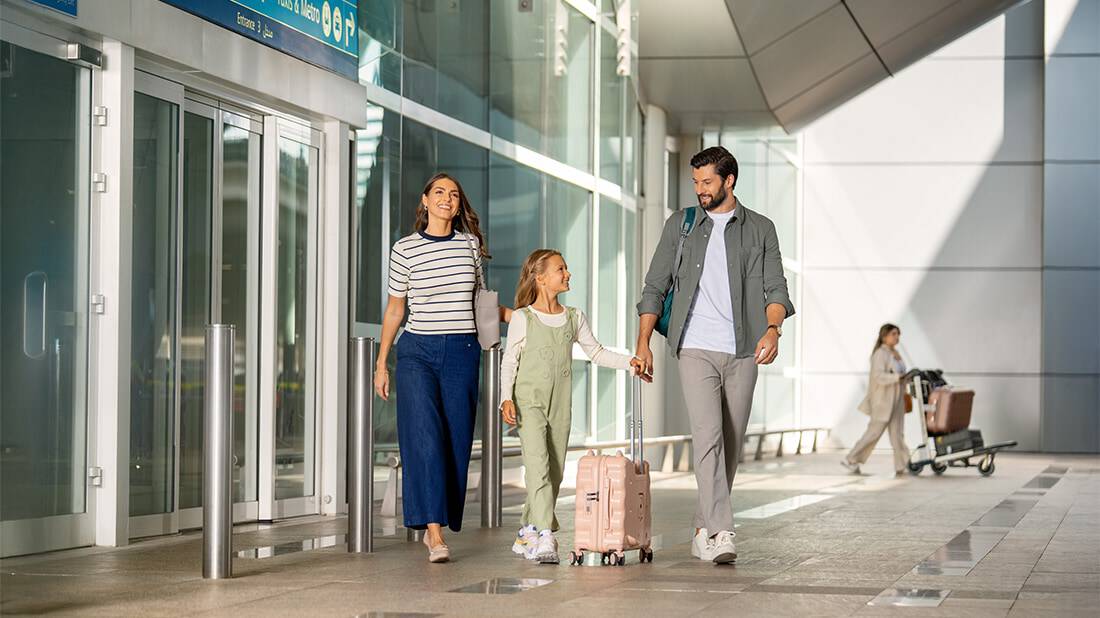 A family of three walking out of the airport