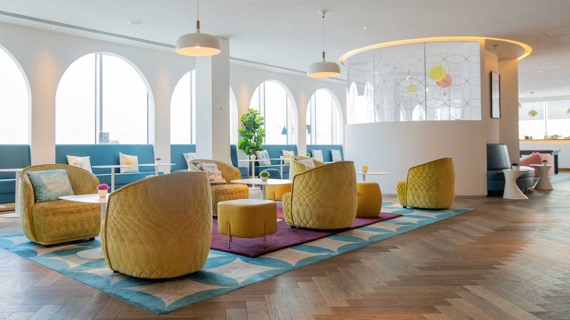 Yellow armchairs seating area at Plaza Premium Lounge London Gatwick Airport