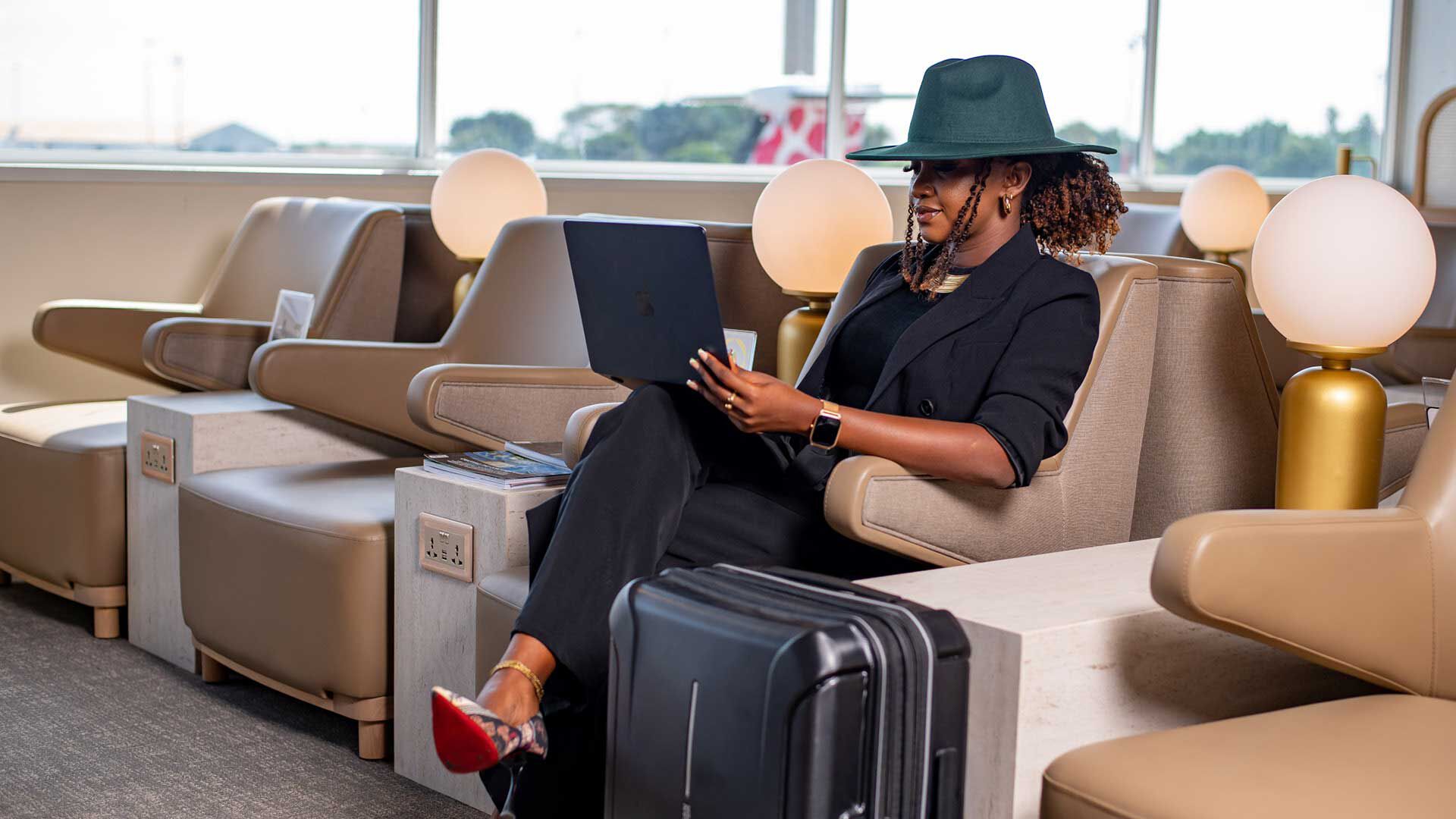 An African female traveller checking her laptop at the Plaza Premium Lounge