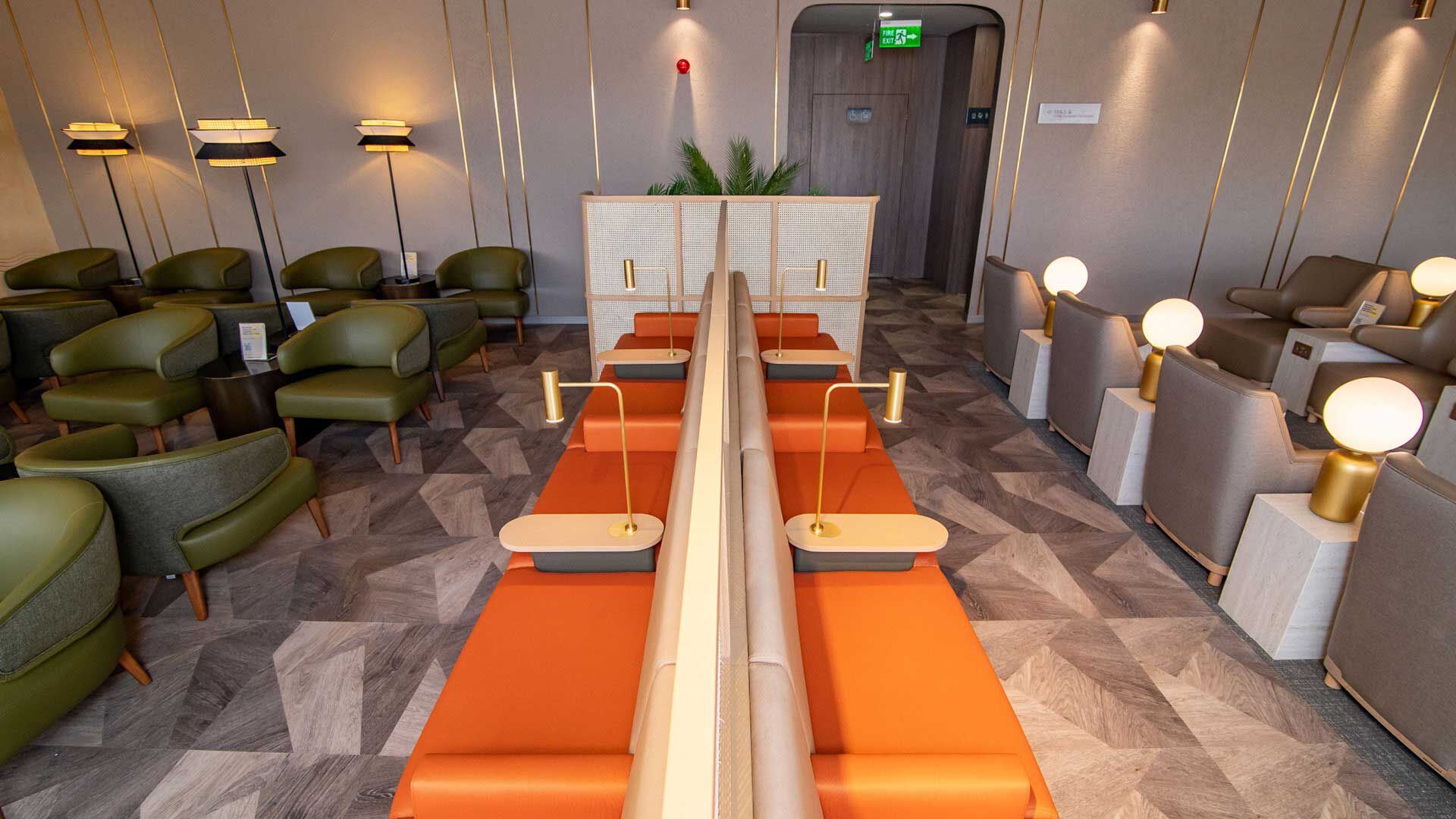 Reading area with orange seats and reading lights at Plaza Premium Lounge