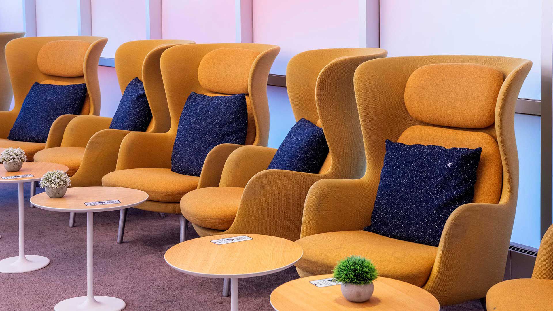 Yellow armchairs with blue cushions lined next to each other in the lounge