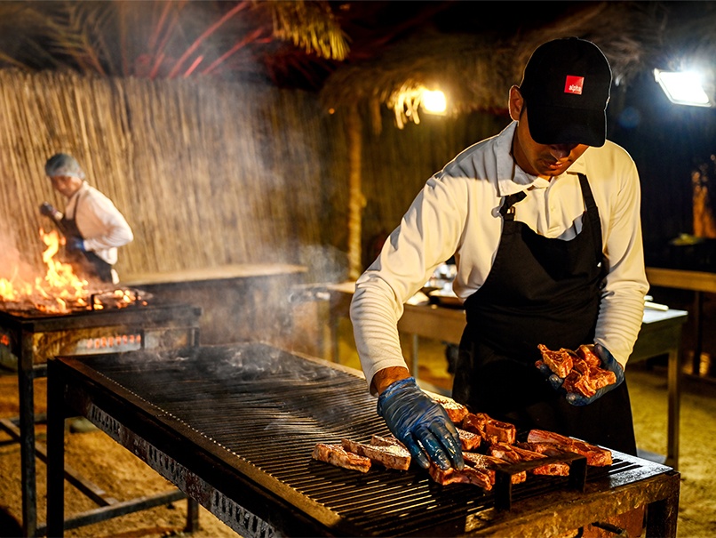 Desert safari A photograph showing a chef cooking a variety of meats on a large BBQ